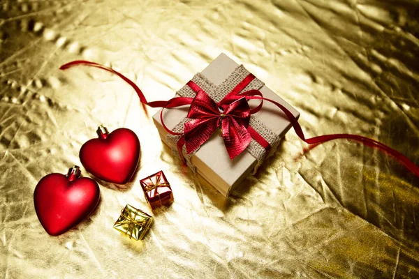 Cuori rossi con confezione regalo su sfondo dorato. giorno di San Valentino — Foto Stock