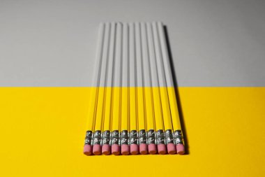 iki renkli arka plan üzerinde birkaç kalem sarı ve gri