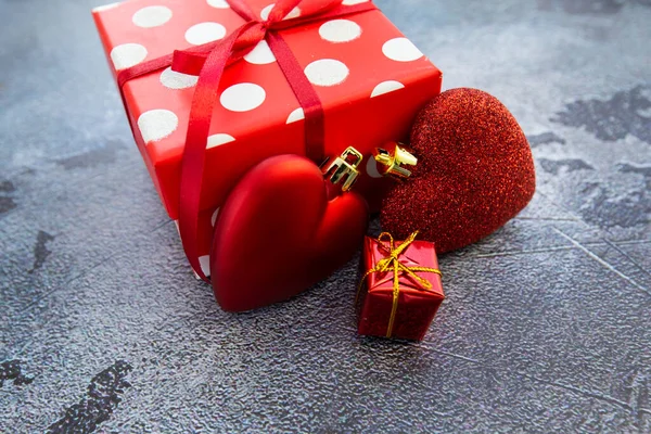 Rode polka dot geschenkdoos met hartjes op grijze betonnen achtergrond — Stockfoto