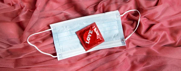 Medizinische Maske Und Kondom Auf Rosa Tüll Stoff Valentinstag Schutzkonzept — Stockfoto