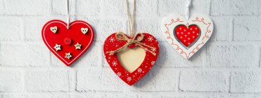 Beyaz tuğlalı arka planda dekoratif kırmızı sevgililer günü konsepti.