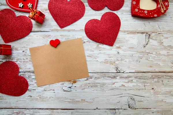 red valentine hearts with card for text on a wooden background. valentine\'s day. top view