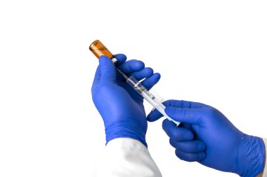 Bir doktor şırıngayı aşı ile doldurur.