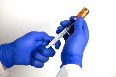 Bir doktor şırıngayı aşı ile doldurur.