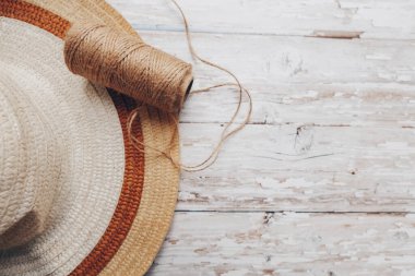 Tahta arka planda bej bir sicim ve hasır bir şapka. Dikiş için sicim. Yüksek kalite fotoğraf