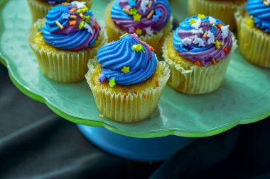 Tek boynuzlu at mini kekleri, mavi şekerli ve renkli tatlı yiyecekleri var.
