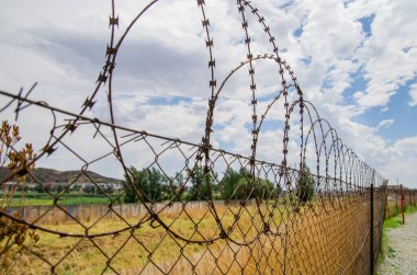 Çitteki dikenli tellerin yakın görüntüsü. Mülkün korunması. Koruyucu çit. 