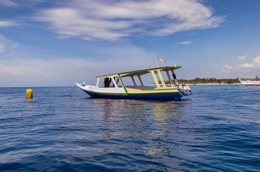 Tahta balıkçı teknesinin manzarası. Okyanusta güzel berrak su, arkada mavi gökyüzü.. 