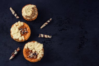 Küçük peynirli keklerin en üst görüntüsü. Kremalı ve çikolata talaşlı mini chessecakeler. Metin için boş alanı olan kompozisyon.