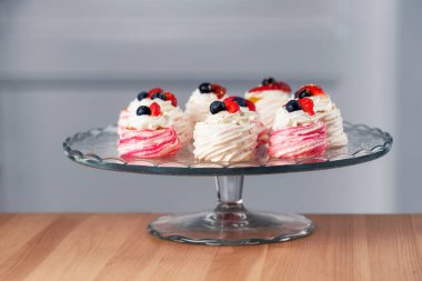 Mini Pavlova keklerini kapat. Krema soslu ve meyveli krema.