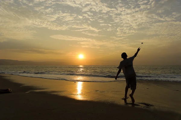 Playa chico lanzando piedra —  Fotos de Stock