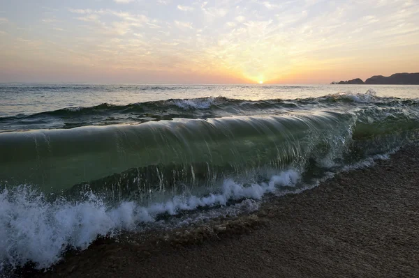 Wave breken op strand oceaan zonsondergang — Stockfoto