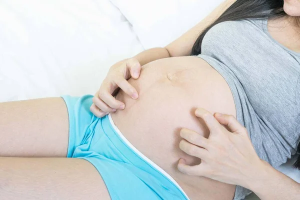 Women scratch the itchy skin. pregnant woman Concept allergy.Pregnant woman scratching her belly