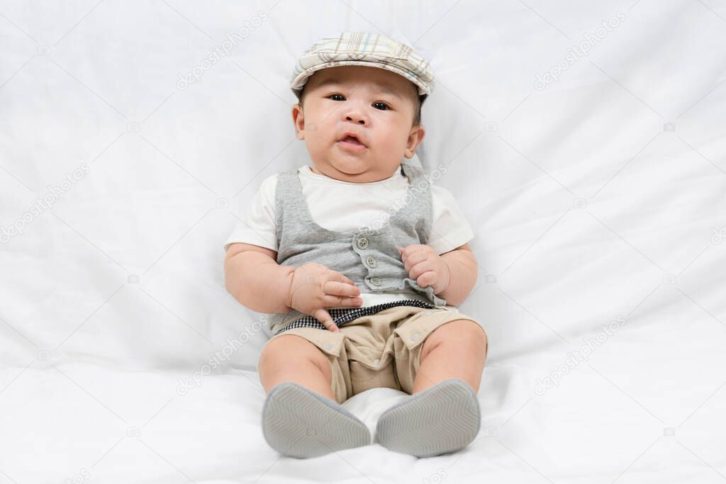 portrait of adorable little baby boy on white wall background. Innocence and babyhood. Fashion kid clothes.