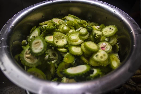 Çelik kabın içinde taze yeşil sebzeler.