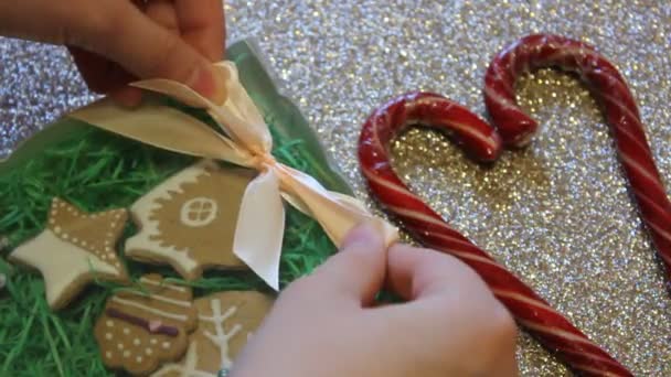 Les mains féminines attachent noeud cadeau sur une boîte cadeau de biscuits au gingembre. Cadeau de Noël — Video