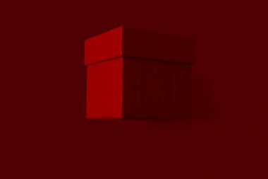 Kırmızı arka planda Noel kırmızı hediye paketi. Minimalist hediye paketi. Sevgililer Günü hediye paketi.