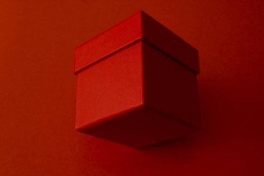 Kırmızı arka planda Noel kırmızı hediye paketi. Minimalist hediye paketi. Sevgililer Günü hediye paketi.