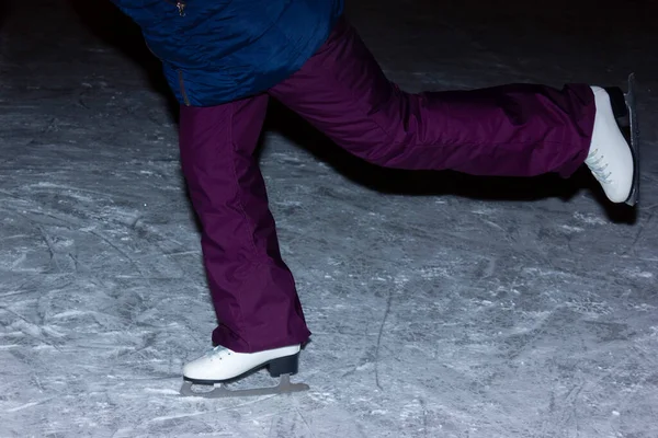 Young woman ice skating outdoors on a pond on a freezing winter day at night - detail of the legs.night winter ice skating. skates feet. ice skates. — Stock Photo, Image