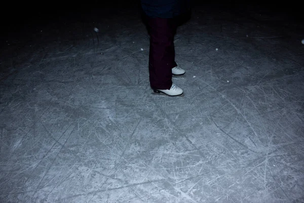 Jeune femme patinant à l'extérieur sur un étang par un jour d'hiver glacial la nuit détail des jambes.patinage hivernal de nuit. patins pieds. patins à glace. — Photo