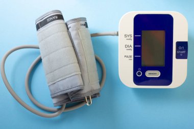 Dijital kan basıncı tonometresi mavi arka planda izole edildi. Kan basıncı monitörü.