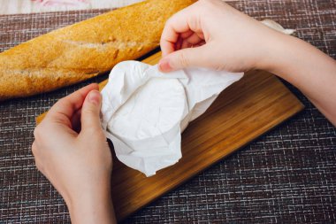 DIY fırında peynirli camembert talimatı. Adım adım. Camembert 'in beyaz kâğıt ambalajlı peynirini açarak. Küflü peynirle.