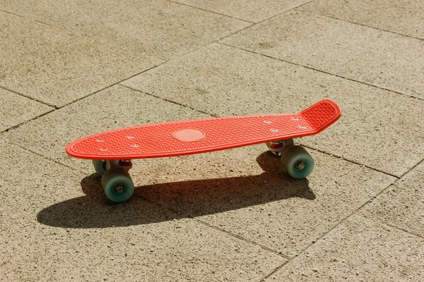 Penny board sull'asfalto. piccolo skateboard di plastica. rosa penny Board con ruote blu — Foto Stock