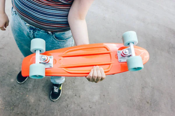 Fechar menina elegante carregando o penny board na cidade de verão — Fotografia de Stock