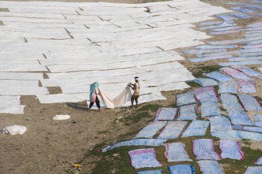 Agra, Hindistan - 15 Şubat 2018: Kimliği belirsiz insanlar Yanuma Agra nehrinin kıyısında sıcak güneşte yıkandıktan sonra bez kurutuyorlar 