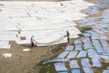 Agra, Hindistan - 15 Şubat 2018: Kimliği belirsiz insanlar Yanuma Agra nehrinin kıyısında sıcak güneşte yıkandıktan sonra bez kurutuyorlar 