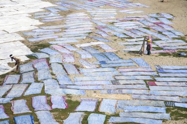 Agra, Hindistan - 15 Şubat 2018: Kimliği belirsiz insanlar Yanuma Agra nehrinin kıyısında sıcak güneşte yıkandıktan sonra bez kurutuyorlar 