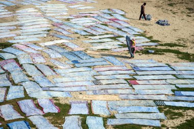 Agra, Hindistan - 15 Şubat 2018: Kimliği belirsiz insanlar Yanuma Agra nehrinin kıyısında sıcak güneşte yıkandıktan sonra bez kurutuyorlar 