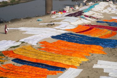 Agra, Hindistan - 15 Şubat 2018: Kimliği belirsiz insanlar Yanuma Agra nehrinin kıyısında sıcak güneşte yıkandıktan sonra bez kurutuyorlar 