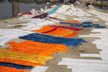 Agra, Hindistan - 15 Şubat 2018: Kimliği belirsiz insanlar Yanuma Agra nehrinin kıyısında sıcak güneşte yıkandıktan sonra bez kurutuyorlar 