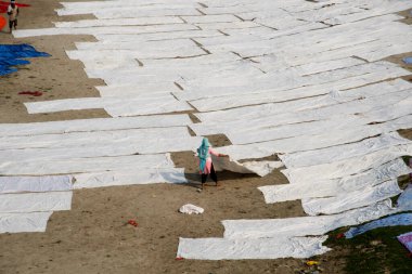 Agra, Hindistan - 15 Şubat 2018: Kimliği belirsiz insanlar Yanuma Agra nehrinin kıyısında sıcak güneşte yıkandıktan sonra bez kurutuyorlar 