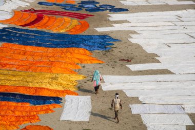 Agra, Hindistan - 15 Şubat 2018: Kimliği belirsiz insanlar Yanuma Agra nehrinin kıyısında sıcak güneşte yıkandıktan sonra bez kurutuyorlar 