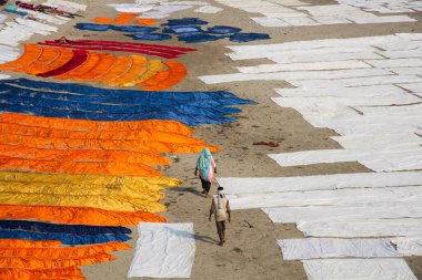 Agra, Hindistan - 15 Şubat 2018: Kimliği belirsiz insanlar Yanuma Agra nehrinin kıyısında sıcak güneşte yıkandıktan sonra bez kurutuyorlar 