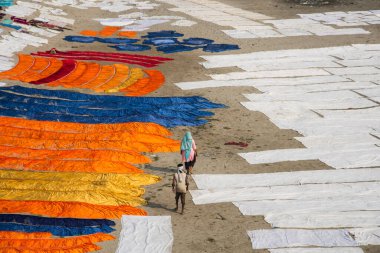 Agra, Hindistan - 15 Şubat 2018: Kimliği belirsiz insanlar Yanuma Agra nehrinin kıyısında sıcak güneşte yıkandıktan sonra bez kurutuyorlar 