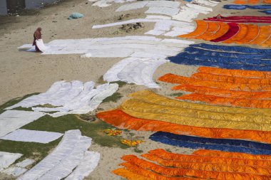 Agra, Hindistan - 15 Şubat 2018: Kimliği belirsiz insanlar Yanuma Agra nehrinin kıyısında sıcak güneşte yıkandıktan sonra bez kurutuyorlar 