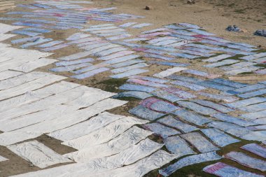 Agra, Hindistan - 15 Şubat 2018: Kimliği belirsiz insanlar Yanuma Agra nehrinin kıyısında sıcak güneşte yıkandıktan sonra bez kurutuyorlar 