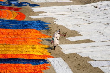 Agra, Hindistan - 15 Şubat 2018: Kimliği belirsiz insanlar Yanuma Agra nehrinin kıyısında sıcak güneşte yıkandıktan sonra bez kurutuyorlar 