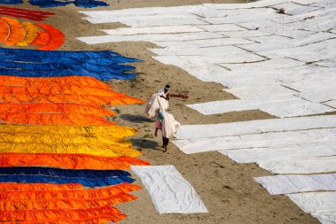 Agra, Hindistan - 15 Şubat 2018: Kimliği belirsiz insanlar Yanuma Agra nehrinin kıyısında sıcak güneşte yıkandıktan sonra bez kurutuyorlar 