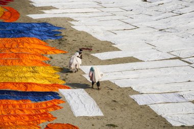 Agra, Hindistan - 15 Şubat 2018: Kimliği belirsiz insanlar Yanuma Agra nehrinin kıyısında sıcak güneşte yıkandıktan sonra bez kurutuyorlar 