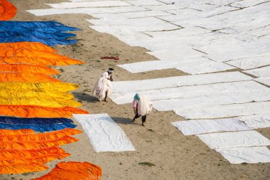 Agra, Hindistan - 15 Şubat 2018: Kimliği belirsiz insanlar Yanuma Agra nehrinin kıyısında sıcak güneşte yıkandıktan sonra bez kurutuyorlar 