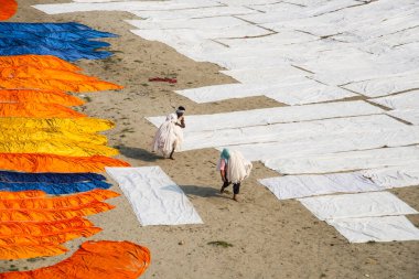 Agra, Hindistan - 15 Şubat 2018: Kimliği belirsiz insanlar Yanuma Agra nehrinin kıyısında sıcak güneşte yıkandıktan sonra bez kurutuyorlar 
