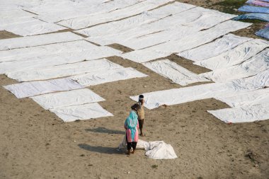 Agra, Hindistan - 15 Şubat 2018: Kimliği belirsiz insanlar Yanuma Agra nehrinin kıyısında sıcak güneşte yıkandıktan sonra bez kurutuyorlar 