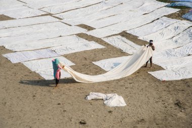 Agra, Hindistan - 15 Şubat 2018: Kimliği belirsiz insanlar Yanuma Agra nehrinin kıyısında sıcak güneşte yıkandıktan sonra bez kurutuyorlar 
