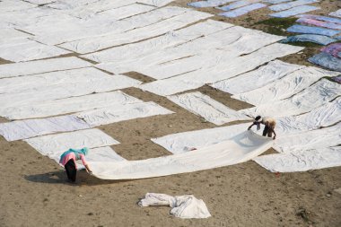 Agra, Hindistan - 15 Şubat 2018: Kimliği belirsiz insanlar Yanuma Agra nehrinin kıyısında sıcak güneşte yıkandıktan sonra bez kurutuyorlar 