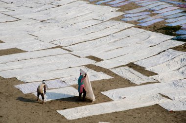 Agra, Hindistan - 15 Şubat 2018: Kimliği belirsiz insanlar Yanuma Agra nehrinin kıyısında sıcak güneşte yıkandıktan sonra bez kurutuyorlar 