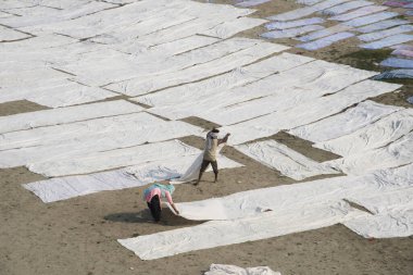 Agra, Hindistan - 15 Şubat 2018: Kimliği belirsiz insanlar Yanuma Agra nehrinin kıyısında sıcak güneşte yıkandıktan sonra bez kurutuyorlar 